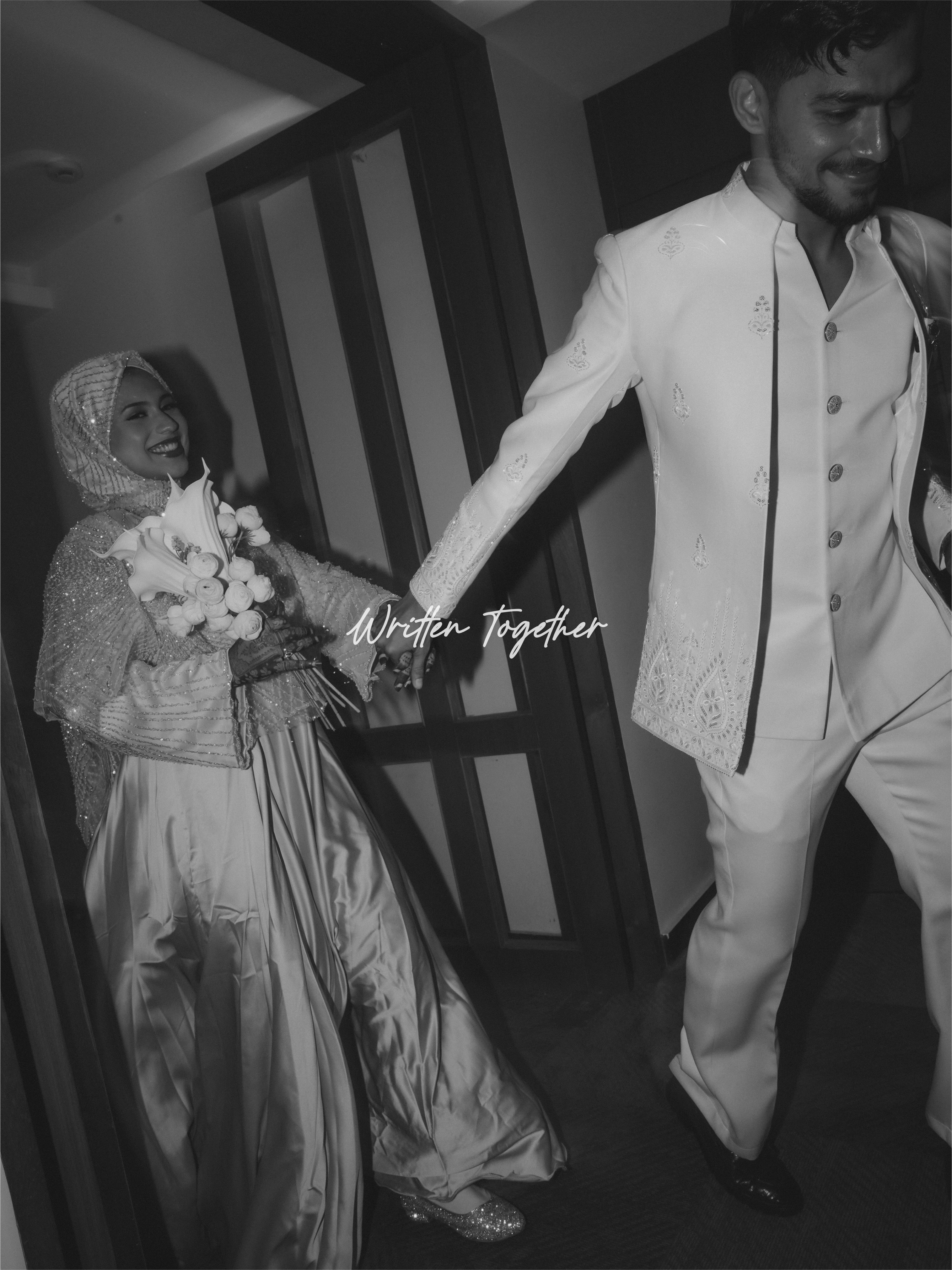 Newlyweds holding hands in a black-and-white portrait