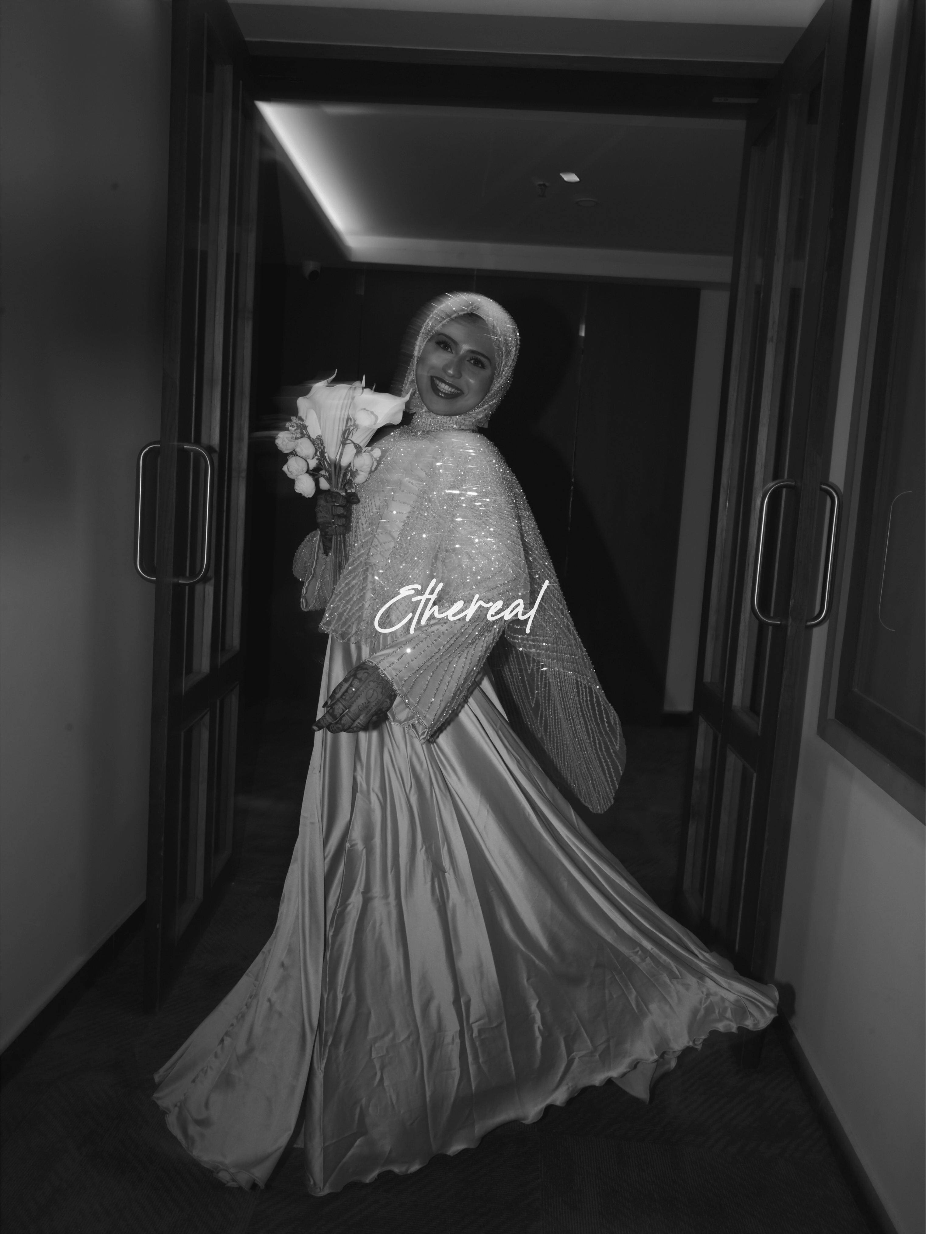 Bride holding a bouquet in a black-and-white portrait